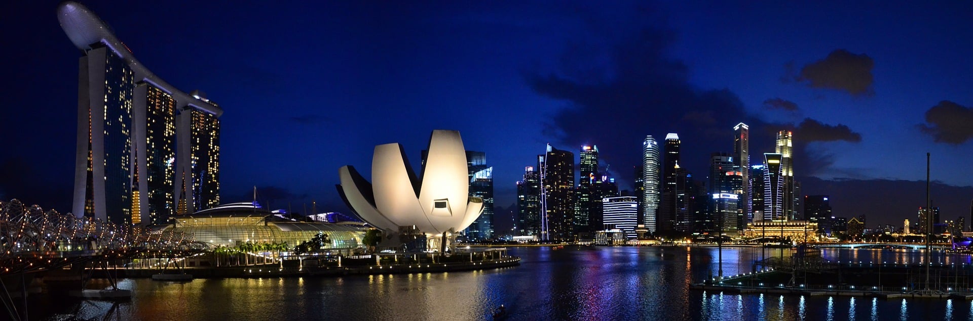 Singapour : Marina Bay de nuit avec gratte-ciels illuminés.